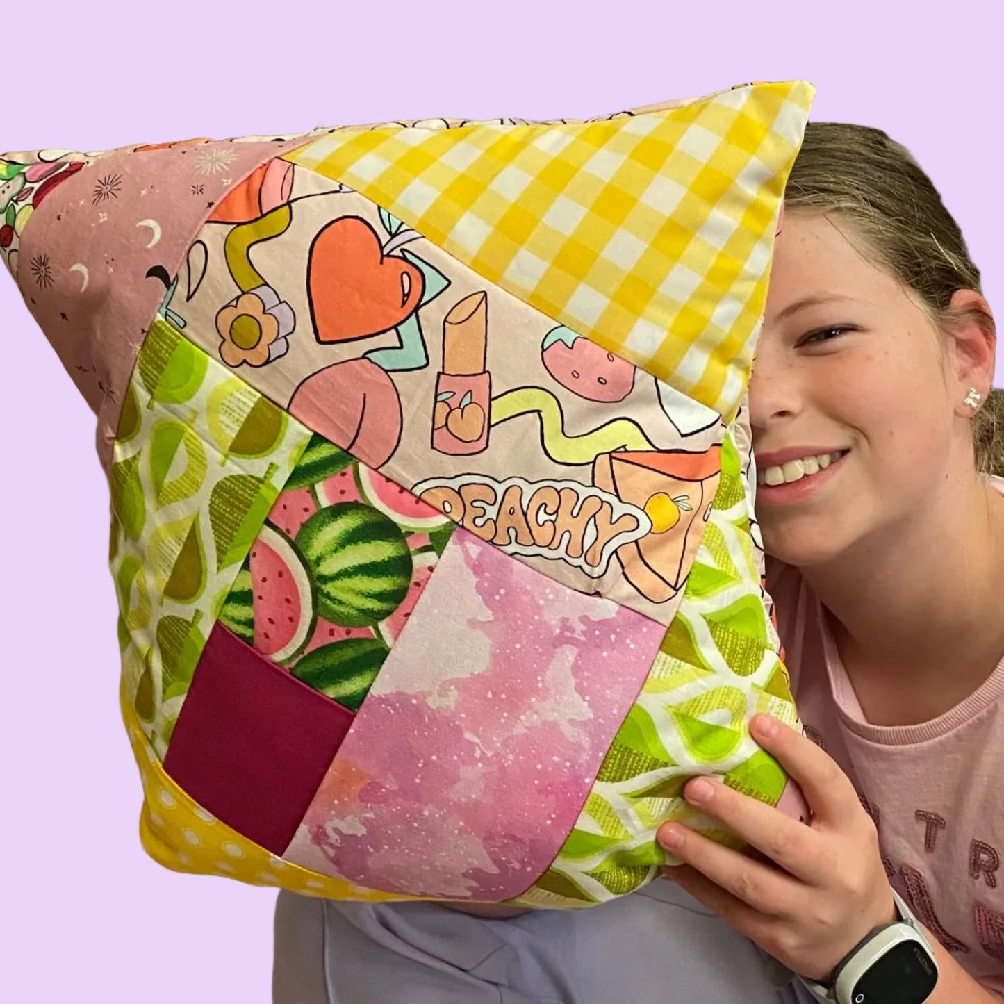 Person holding a colorful patchwork pillow with cartoon designs